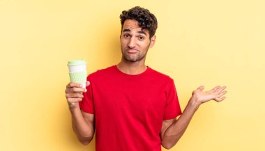 İspanyol yakışıklı adam şaşkın, şaşkın ve şüpheci hissediyor. kahve konseptini kaldır.