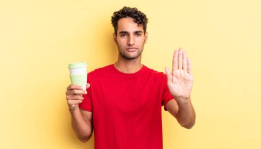 İspanyol yakışıklı adam ciddi görünüyor. Avuç içi gösteriyor. Durdurma hareketi yapıyor. kahve konseptini kaldır.