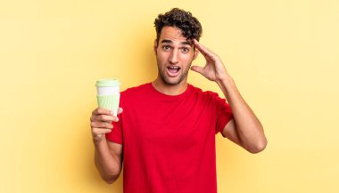 İspanyol yakışıklı adam mutlu, şaşkın ve şaşırmış görünüyor. kahve konseptini kaldır.