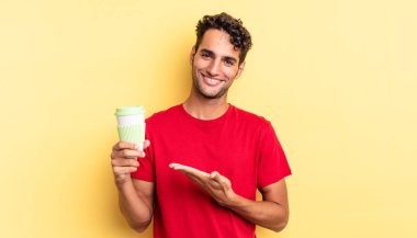 İspanyol yakışıklı adam neşeyle gülümsüyor, mutlu hissediyor ve bir konsept gösteriyor. kahve konseptini kaldır.