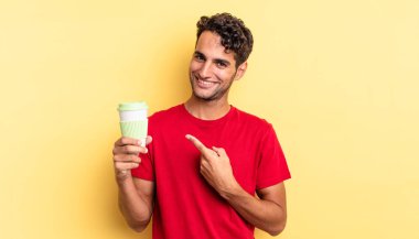 İspanyol yakışıklı adam neşeyle gülümsüyor, mutlu hissediyor ve bir tarafı işaret ediyor. kahve konseptini kaldır.