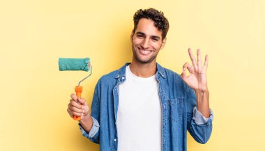 İspanyol yakışıklı adam kendini mutlu hissediyor, iyi bir jestle onaylıyor. paten boya kavramı