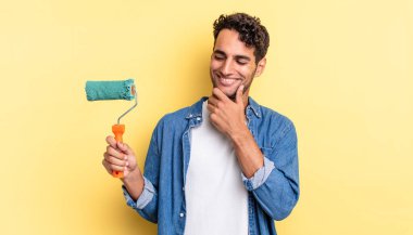 Mutlu, kendine güvenen, elleri çenesinde gülümseyen İspanyol yakışıklı bir adam. paten boya kavramı