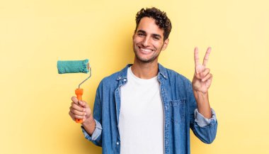 İspanyol yakışıklı adam gülümsüyor ve mutlu görünüyor, zafer ya da barış işareti yapıyor. paten boya kavramı