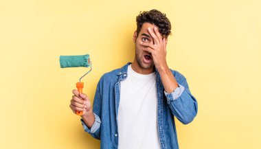 İspanyol yakışıklı adam şok olmuş, korkmuş ya da korkmuş görünüyor. Yüzü elle kapatılmış. paten boya kavramı