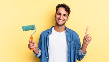 İspanyol yakışıklı adam gülümsüyor ve arkadaş canlısı görünüyor, bir numarayı gösteriyor. paten boya kavramı