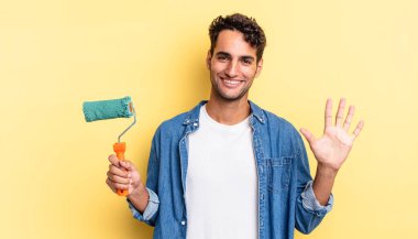 İspanyol yakışıklı adam gülümsüyor ve arkadaş canlısı görünüyor, beş numarayı gösteriyor. paten boya kavramı