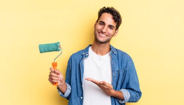 İspanyol yakışıklı adam neşeyle gülümsüyor, mutlu hissediyor ve bir konsept gösteriyor. paten boya kavramı