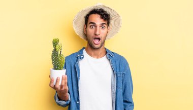 İspanyol yakışıklı adam şok olmuş ya da şaşırmış bir çiftçi ve kaktüs konsepti arıyor.