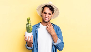 Hispanik yakışıklı adam stresli, endişeli, yorgun ve hayal kırıklığına uğramış çiftçi ve kaktüs kavramı