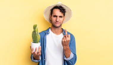 Hispanik yakışıklı adam kızgın, sinirli, asi ve saldırgan çiftçi ve kaktüs kavramı