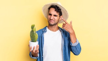 İspanyol yakışıklı adam şaşkın ve şaşkın hissediyor, senin çılgın bir çiftçi ve kaktüs olduğunu gösteriyor.