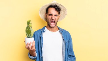 İspanyol yakışıklı adam agresif bir şekilde bağırıyor, kızgın bir çiftçi ve kaktüs gibi bakıyor.
