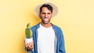 Hispanik yakışıklı adam tiksinmiş ve rahatsız olmuş hissediyor ve çiftçi ve kaktüs kavramını dile getiriyor.