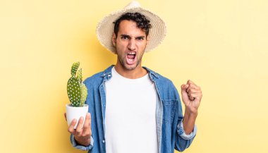 İspanyol yakışıklı adam sinirli bir çiftçi ve kaktüs kavramı ile agresif bir şekilde bağırıyor.