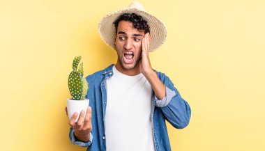 İspanyol yakışıklı adam mutlu, heyecanlı ve şaşırmış çiftçi ve kaktüs konsepti