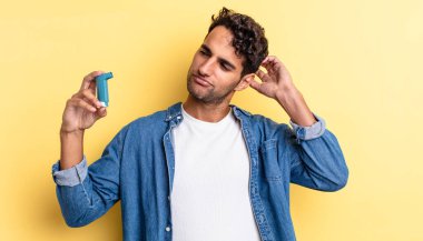 İspanyol yakışıklı adam mutlu bir şekilde gülümsüyor ve hayal kuruyor ya da şüphe ediyor. astım konsepti