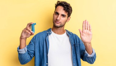 İspanyol yakışıklı adam ciddi görünüyor. Avuç içi gösteriyor. Durdurma hareketi yapıyor. astım konsepti