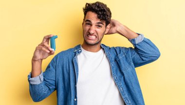 İspanyol yakışıklı adam kendini stresli, endişeli ya da korkmuş hissediyor, elleri başının üstünde. astım konsepti