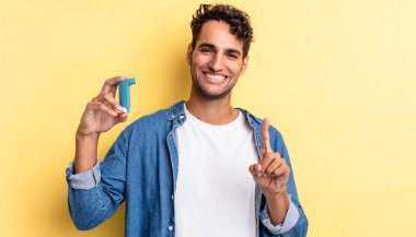 Hispanik yakışıklı adam gururla gülümsüyor ve kendinden emin bir numara oluyor. astım konsepti