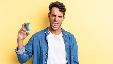 İspanyol yakışıklı adam agresif bir şekilde bağırıyor, çok kızgın görünüyor. astım konsepti