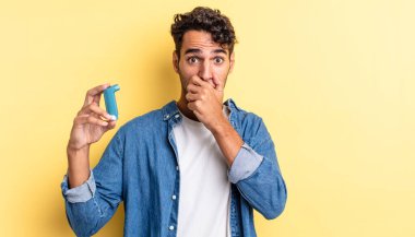 İspanyol yakışıklı adam şok olmuş bir şekilde ağzını kapatıyor. astım konsepti