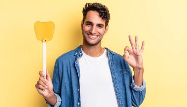 İspanyol yakışıklı adam kendini mutlu hissediyor, iyi bir jestle onaylıyor. Sinekleri öldürür