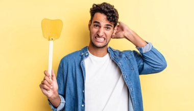 İspanyol yakışıklı adam kendini stresli, endişeli ya da korkmuş hissediyor, elleri başının üstünde. Sinekleri öldürür