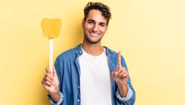 Hispanik yakışıklı adam gururla gülümsüyor ve kendinden emin bir numara oluyor. Sinekleri öldürür