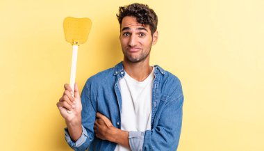 İspanyol yakışıklı adam omuz silkiyor, kafası karışık ve kararsız. Sinekleri öldürür