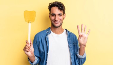 İspanyol yakışıklı adam gülümsüyor ve arkadaş canlısı görünüyor, dört numarayı gösteriyor. Sinekleri öldürür