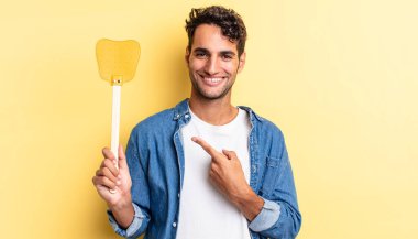 İspanyol yakışıklı adam neşeyle gülümsüyor, mutlu hissediyor ve bir tarafı işaret ediyor. Sinekleri öldürür