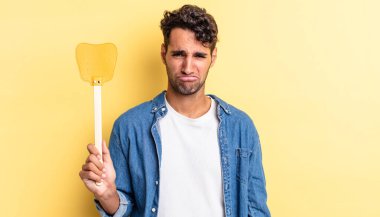 Hispanik yakışıklı adam üzgün ve mızmız, mutsuz bir bakışla ağlıyor. Sinekleri öldürür