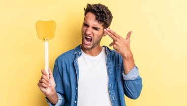 İspanyol yakışıklı adam mutsuz ve stresli görünüyor, intihar jesti silah işareti yapıyor. Sinekleri öldürür