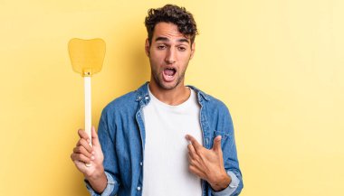 İspanyol yakışıklı adam şok olmuş ve ağzı açık, kendini işaret ederek şaşırmış görünüyor. Sinekleri öldürür