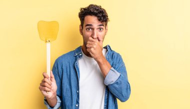 İspanyol yakışıklı adam şok olmuş bir şekilde ağzını kapatıyor. Sinekleri öldürür