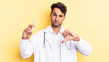 Hispanik yakışıklı adam huysuz hissediyor, başparmaklarını göstermiyor doktor ve srynge konsepti
