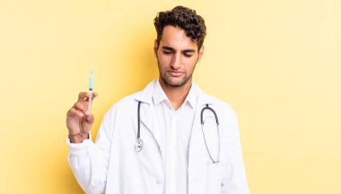 Hispanik yakışıklı adam üzgün, üzgün ya da kızgın hissediyor ve yan hekim ve srynge konseptine bakıyor.