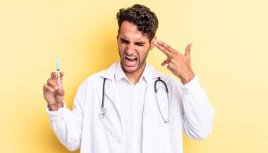 İspanyol yakışıklı adam mutsuz ve stresli görünüyor, intihar jesti silah işareti yapan doktor ve srynge konsepti