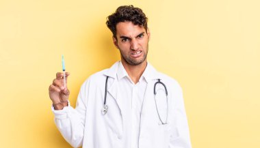 Hispanik yakışıklı adam şaşkın ve şaşkın doktor ve srynge konsepti