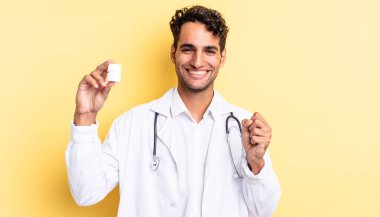 İspanyol yakışıklı adam şokta, gülüyor ve başarıyı kutluyor. Hekim şişesi hapları konsepti