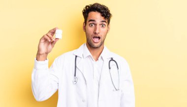 İspanyol yakışıklı adam çok şaşırmış ya da şaşkın görünüyor. Hekim şişesi hapları konsepti