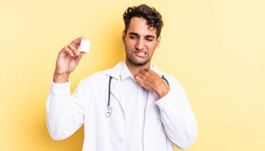 İspanyol yakışıklı adam stresli, endişeli, yorgun ve hayal kırıklığına uğramış hissediyor. Hekim şişesi hapları konsepti