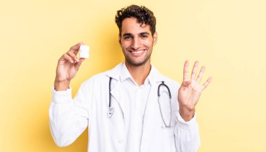 İspanyol yakışıklı adam gülümsüyor ve arkadaş canlısı görünüyor, dört numarayı gösteriyor. Hekim şişesi hapları konsepti