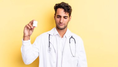 Hispanik yakışıklı adam üzgün, üzgün ya da kızgın hissediyor ve yana bakıyor. Hekim şişesi hapları konsepti