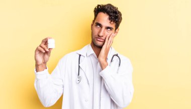 İspanyol yakışıklı bir adam yorgun, bıkkın ve uykulu hissediyor. Hekim şişesi hapları konsepti