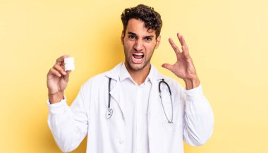 İspanyol yakışıklı adam ellerini havaya kaldırarak bağırıyor. Hekim şişesi hapları konsepti