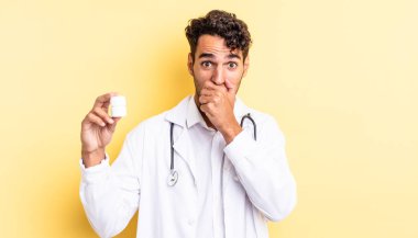 İspanyol yakışıklı adam şok olmuş bir şekilde ağzını kapatıyor. Hekim şişesi hapları konsepti