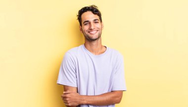 İspanyol yakışıklı adam utangaç ve neşeli bir şekilde gülüyor.