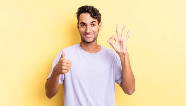 İspanyol yakışıklı adam mutlu, şaşkın, iyi görünüyor ve başparmak kaldırıyor.